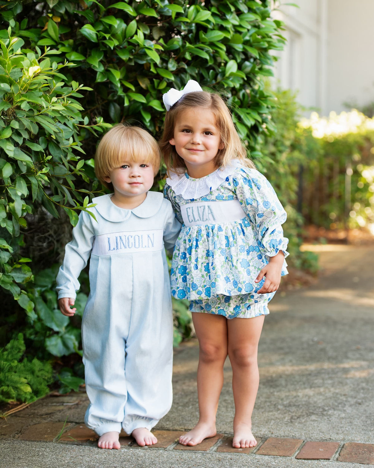 Brother and sister wearing coordinating blue gingham and floral fall outfits
