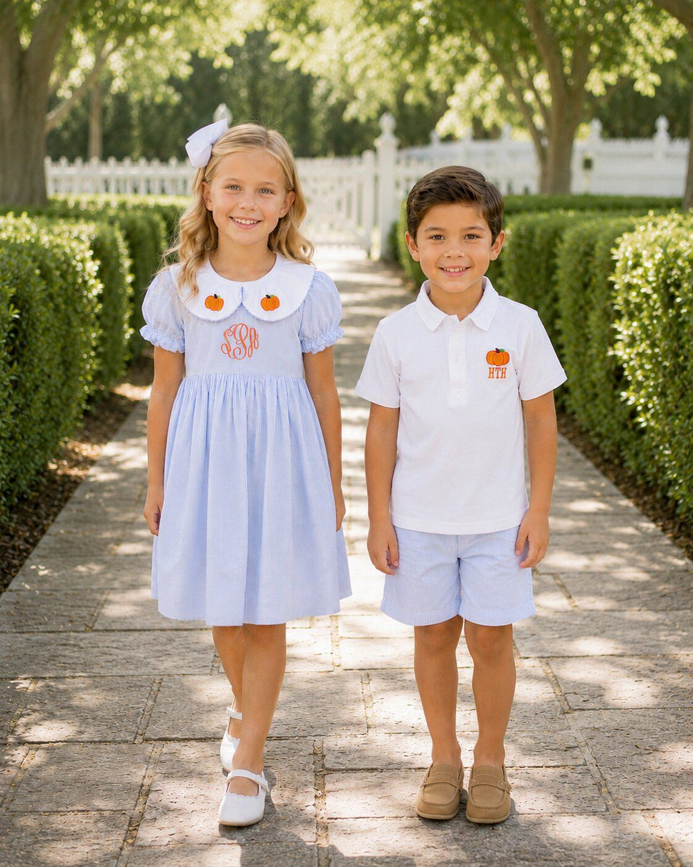 Brother and sister wearing coordinating blue pumpkin outfits for fall and Thanksgiving