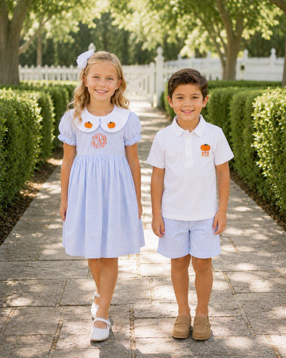 Two children standing on a stone path with greenery in the background