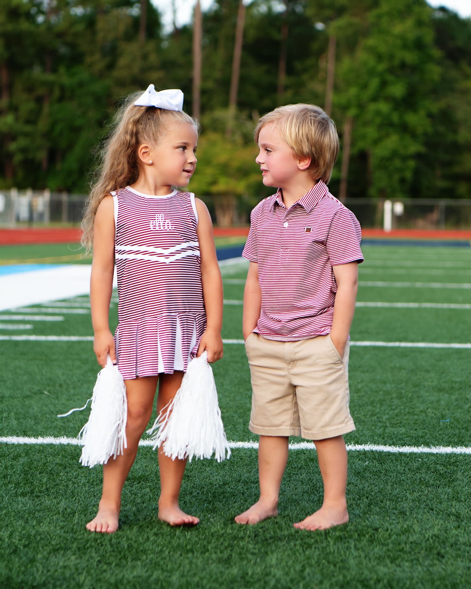 Two children wearing matching outfits on football field 