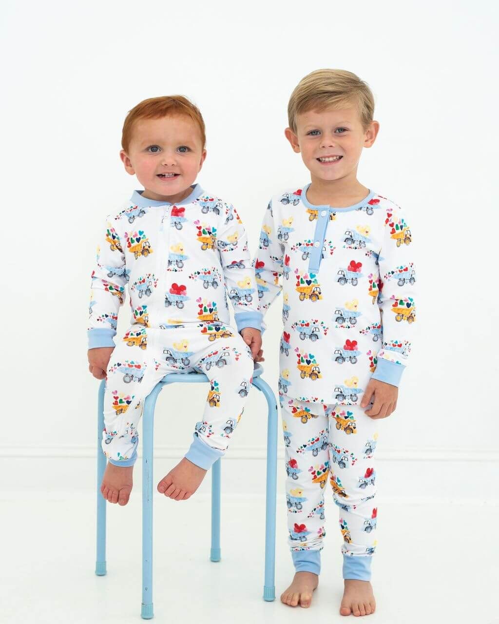 Two children wearing pajamas with cartoon designs on a white background