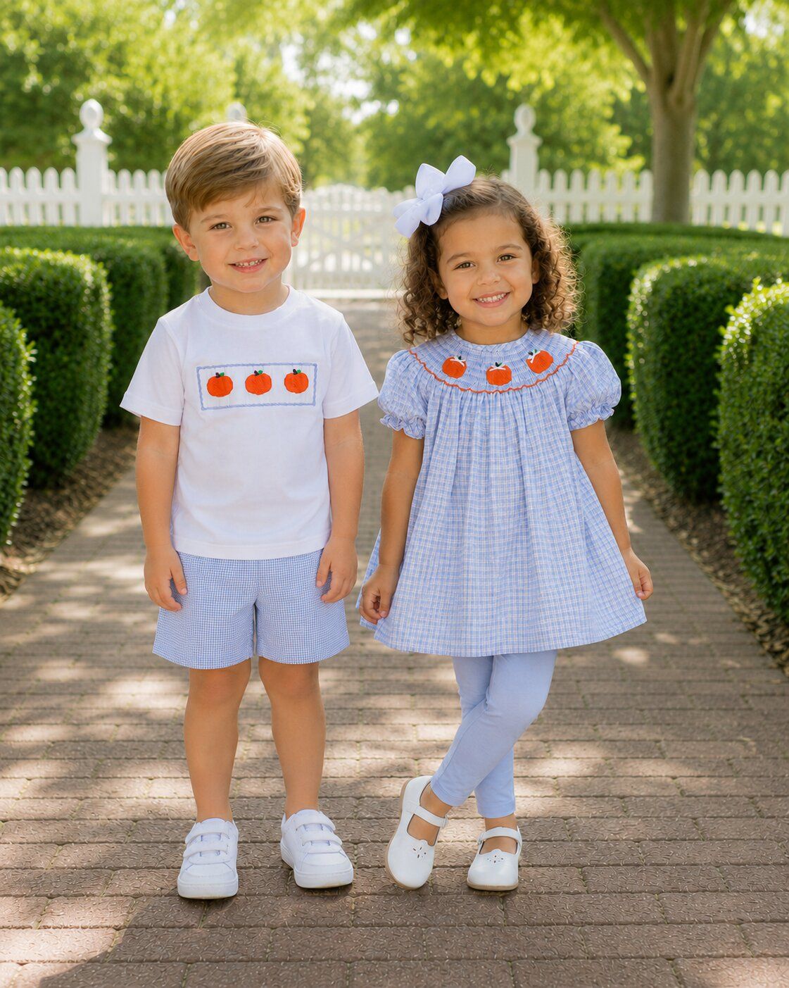 Two kids standing on a path with greenery in the background