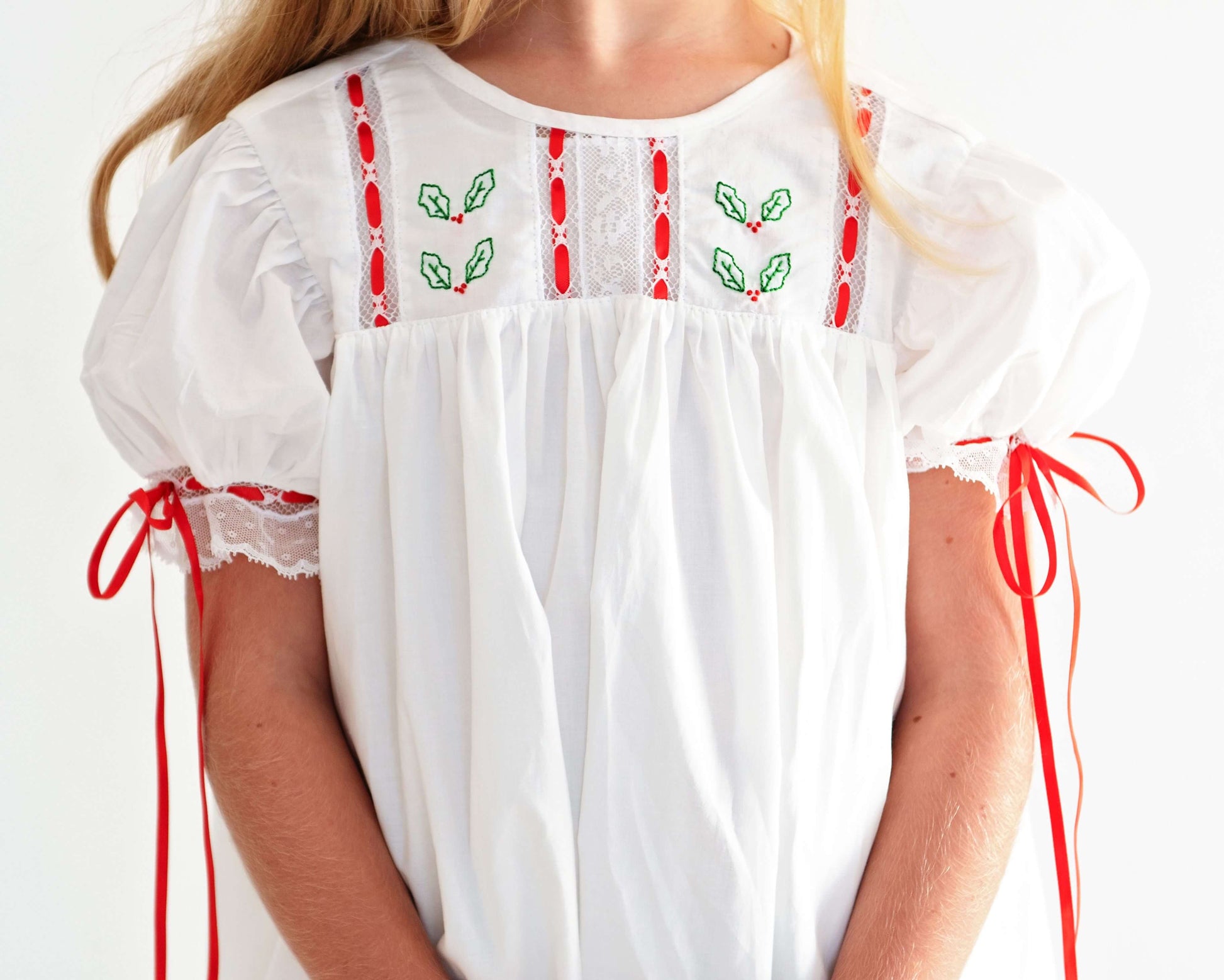White blouse with red and green embroidery on a white background
