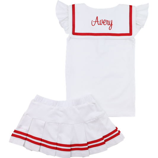 White dress with red trim and 'Avery' monogram, paired with a white skirt with red trim on a white background.