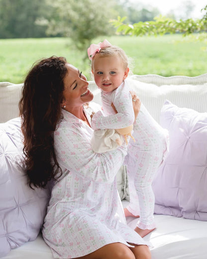 Woman holding a baby on a white couch outdoors