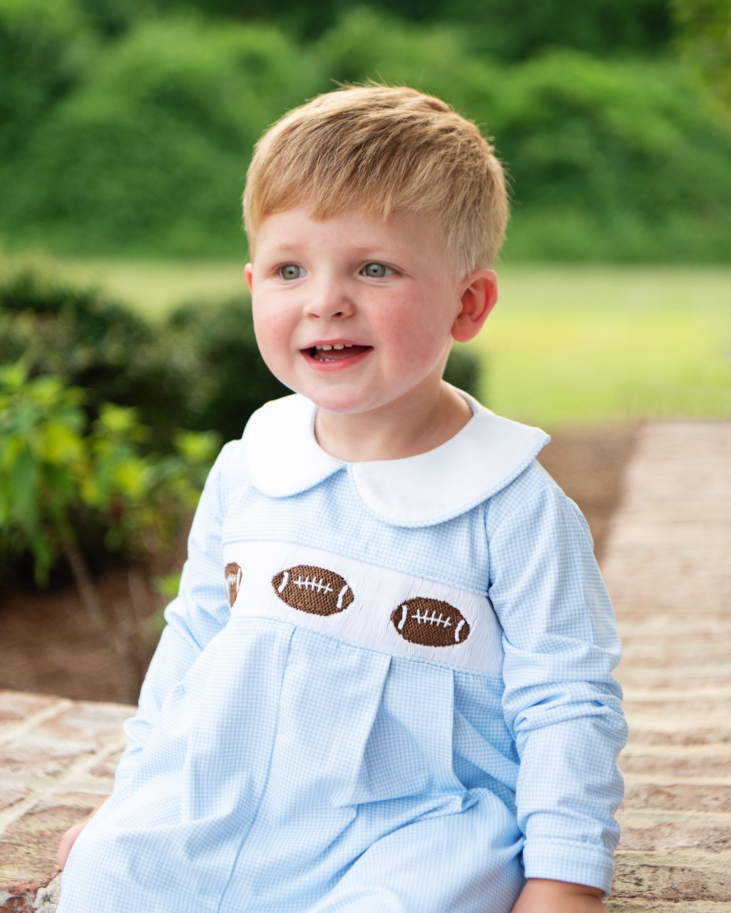 Young boy in Blue Gingham Knit Smocked Footballs Long Romper