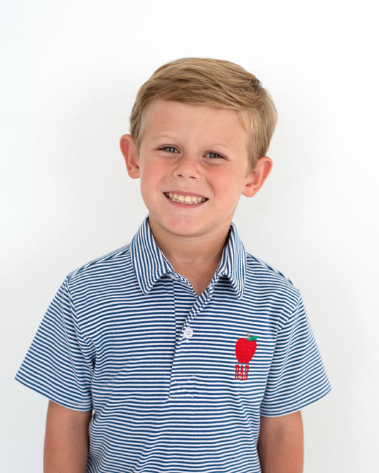 Young boy smiling wearing a navy striped shirt with an apple embroidered.