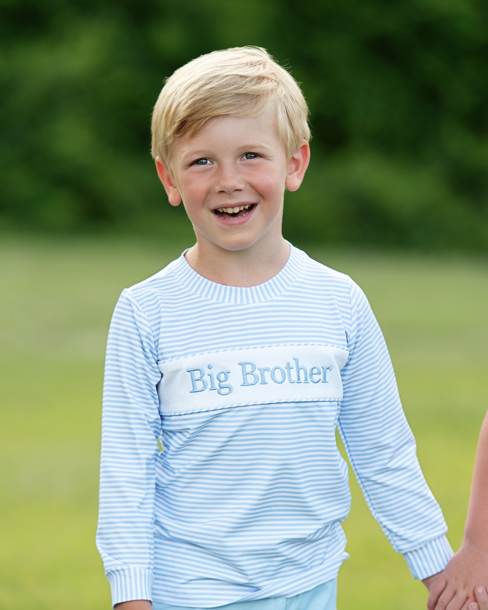 Young boy wearing a 'Big Brother' shirt outdoors