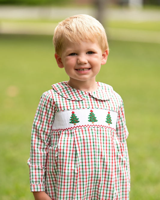 Young boy wearing a Christmas outfit with Christmas trees.