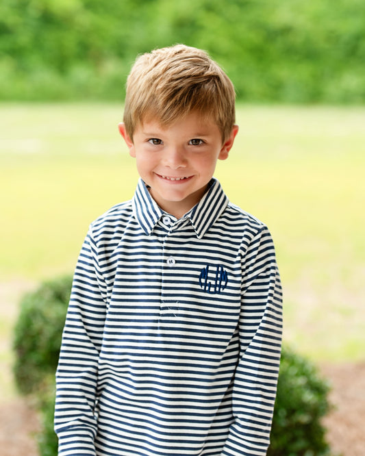 Young boy wearing a navy striped shirt with a blurred background
