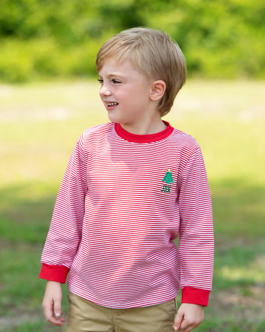 Young boy wearing a red and white striped shirt with a logo outdoors
