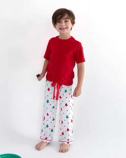 Young boy wearing holiday pajamas standing in a studio.