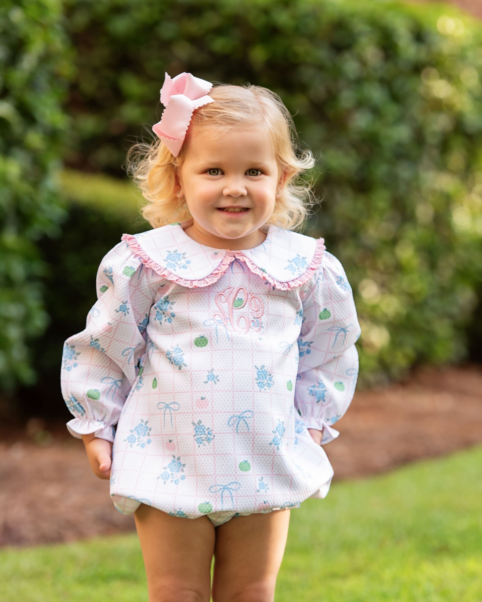 Young girl bubble wearing a pumpkin with a large bow outdoors