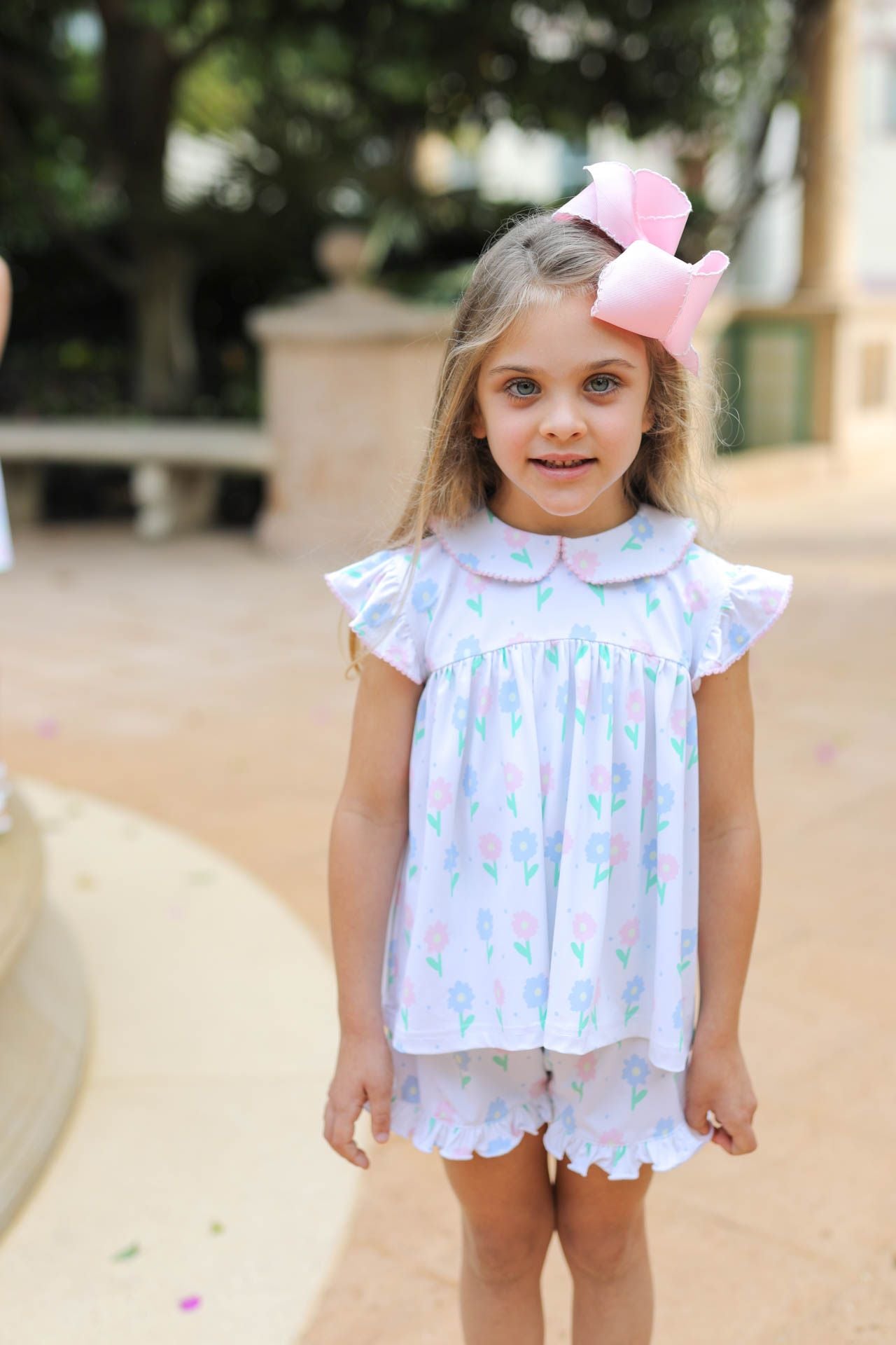 Young girl in a white dress with colorful patterns outdoors