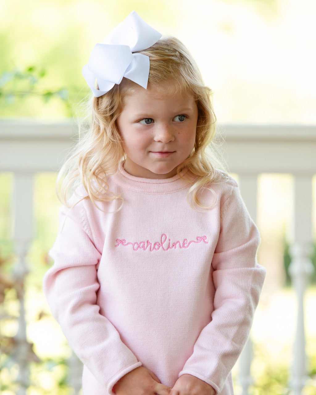 Young girl in pink outfit with caroline embroidered in the center of her chest