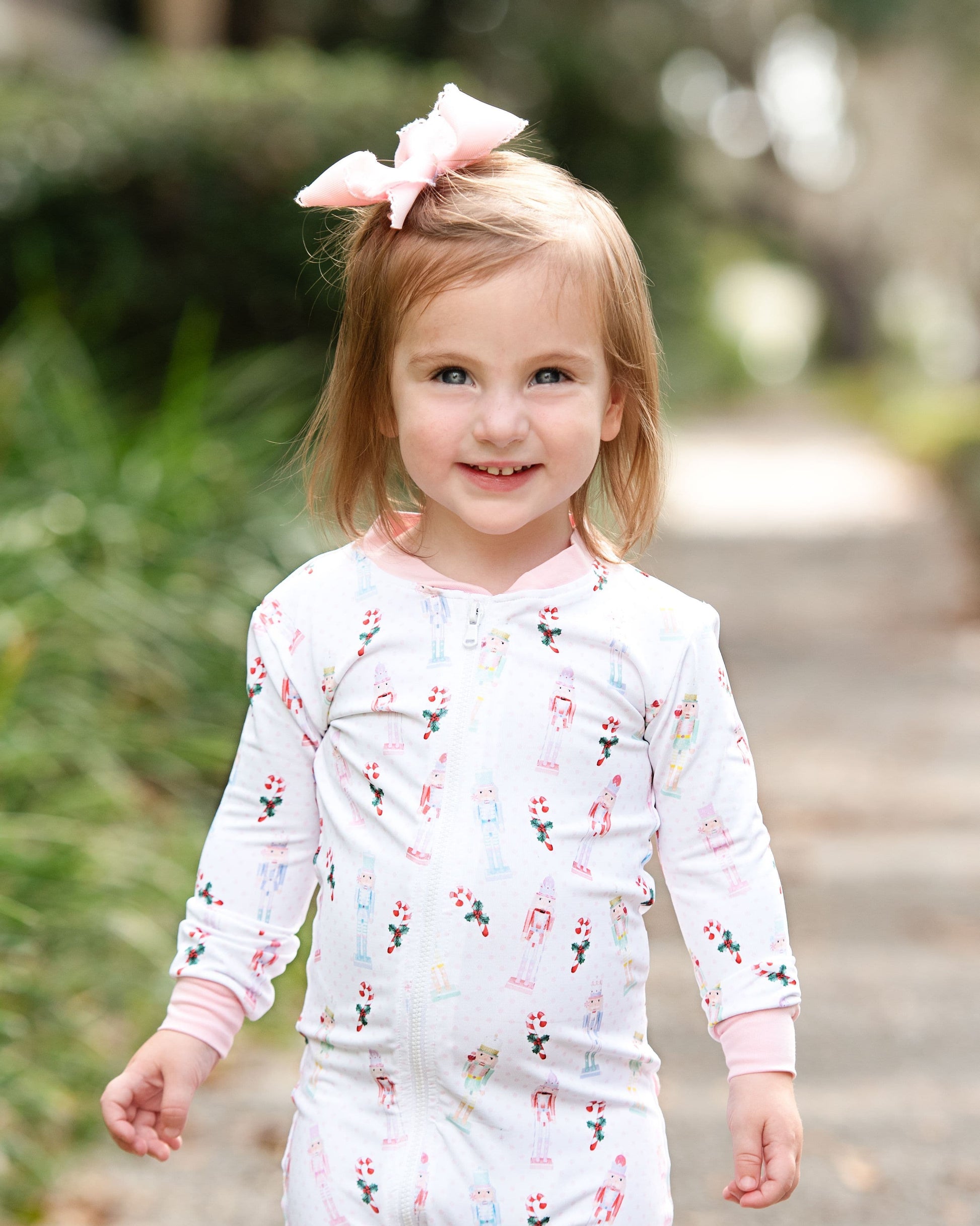 Young girl outside wearing a bow and nutcracker pajamas