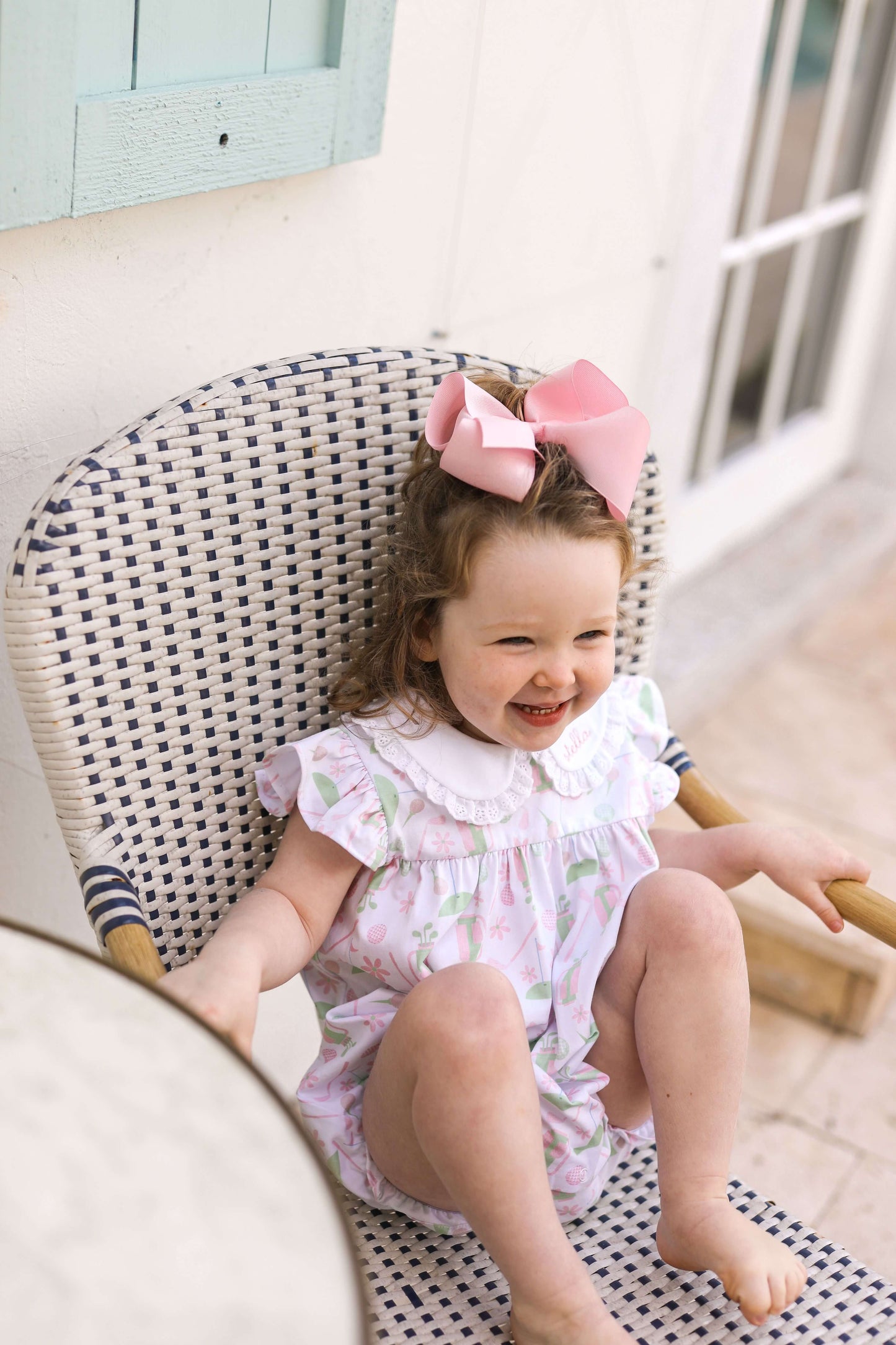 Young girl wearing a bubble sitting outside in a chair