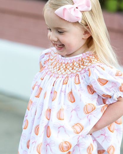Young girl wearing a diaper set with orange and pink patterns outdoors 1