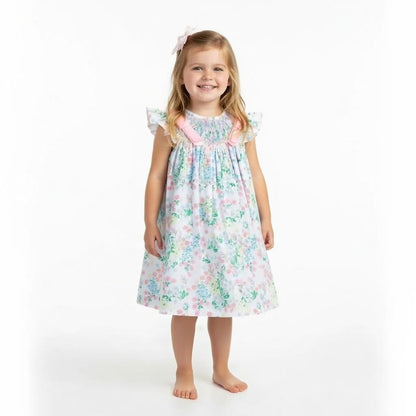 Young girl wearing a floral dress on a white background