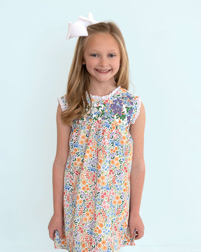 Young girl wearing a floral dress with a blue background