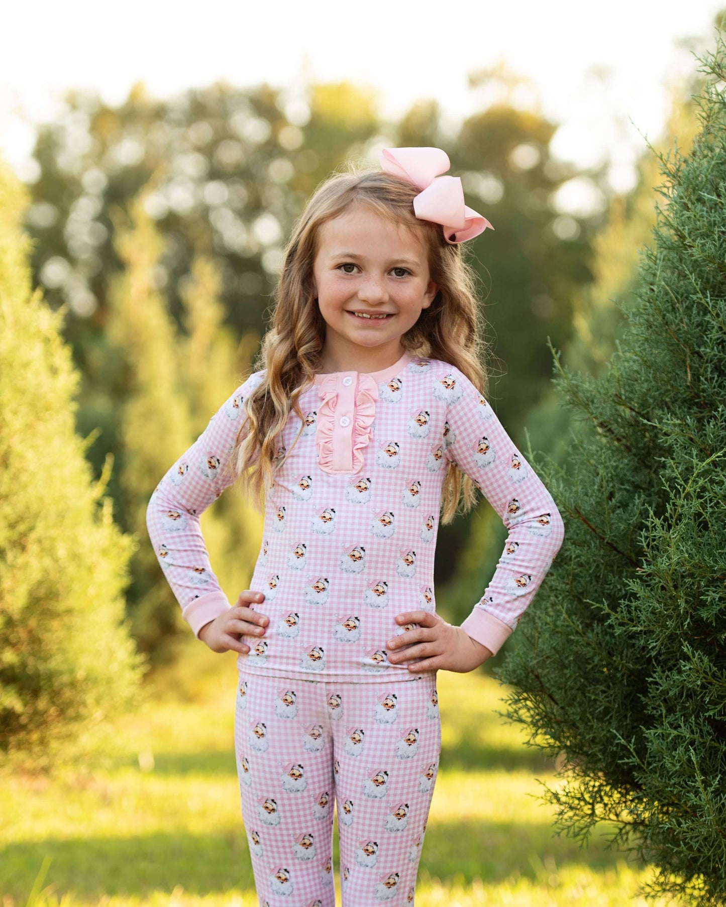 Young girl wearing a pink floral outfit with a matching headband in a garden setting