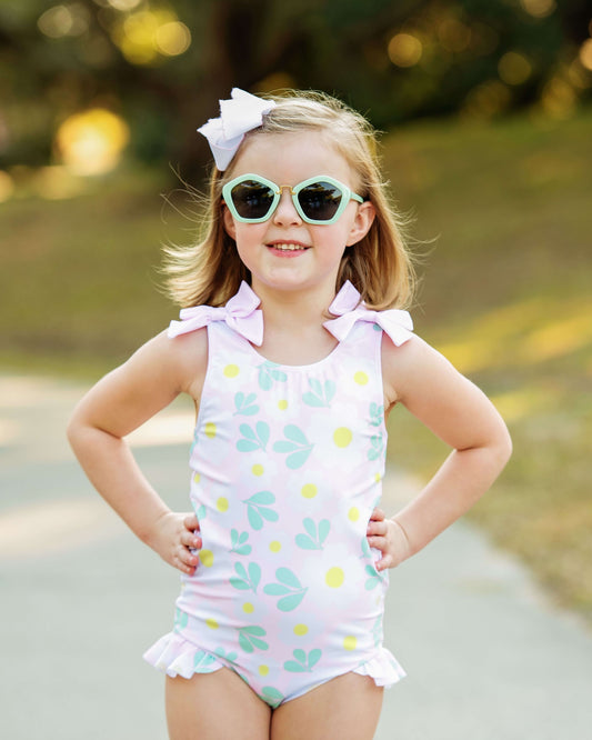 Young girl wearing a polka dot swimsuit with sunglasses outdoors