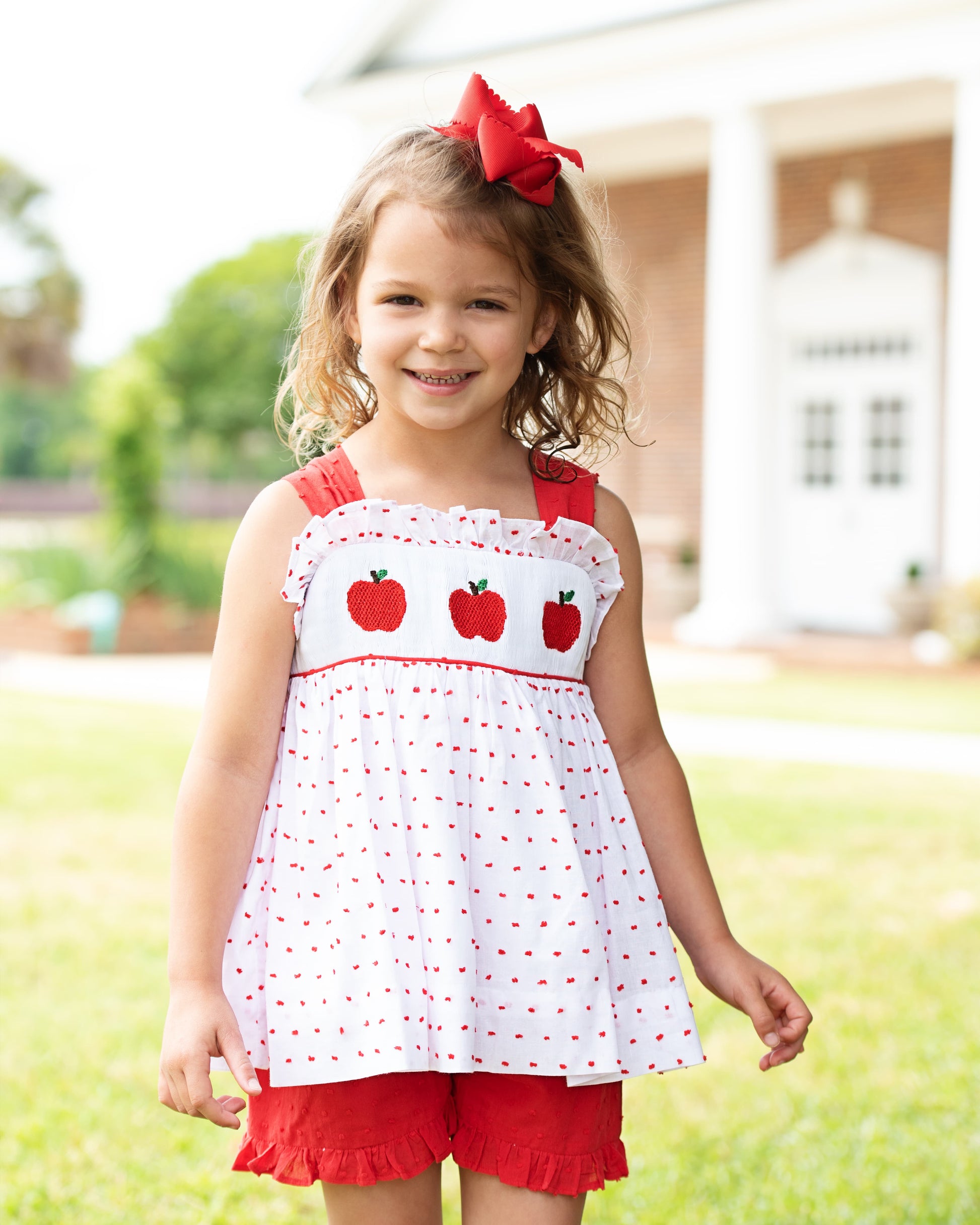Young girl wearing an apple sort set smiling.