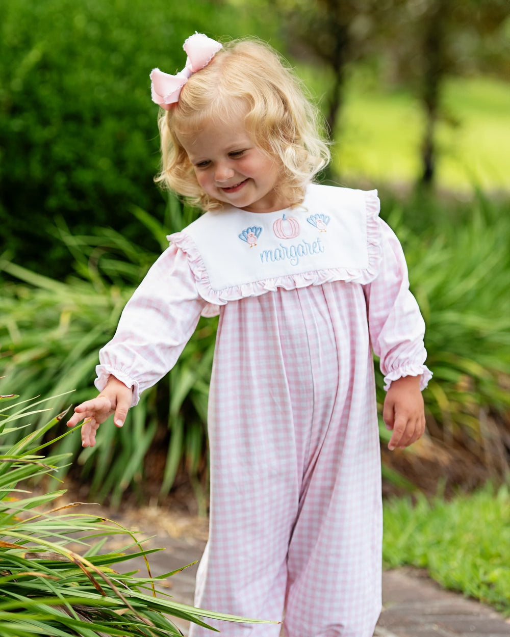 Young girl wearing a personalized pink Thanksgiving long bubble with turkeys and a pumpkin