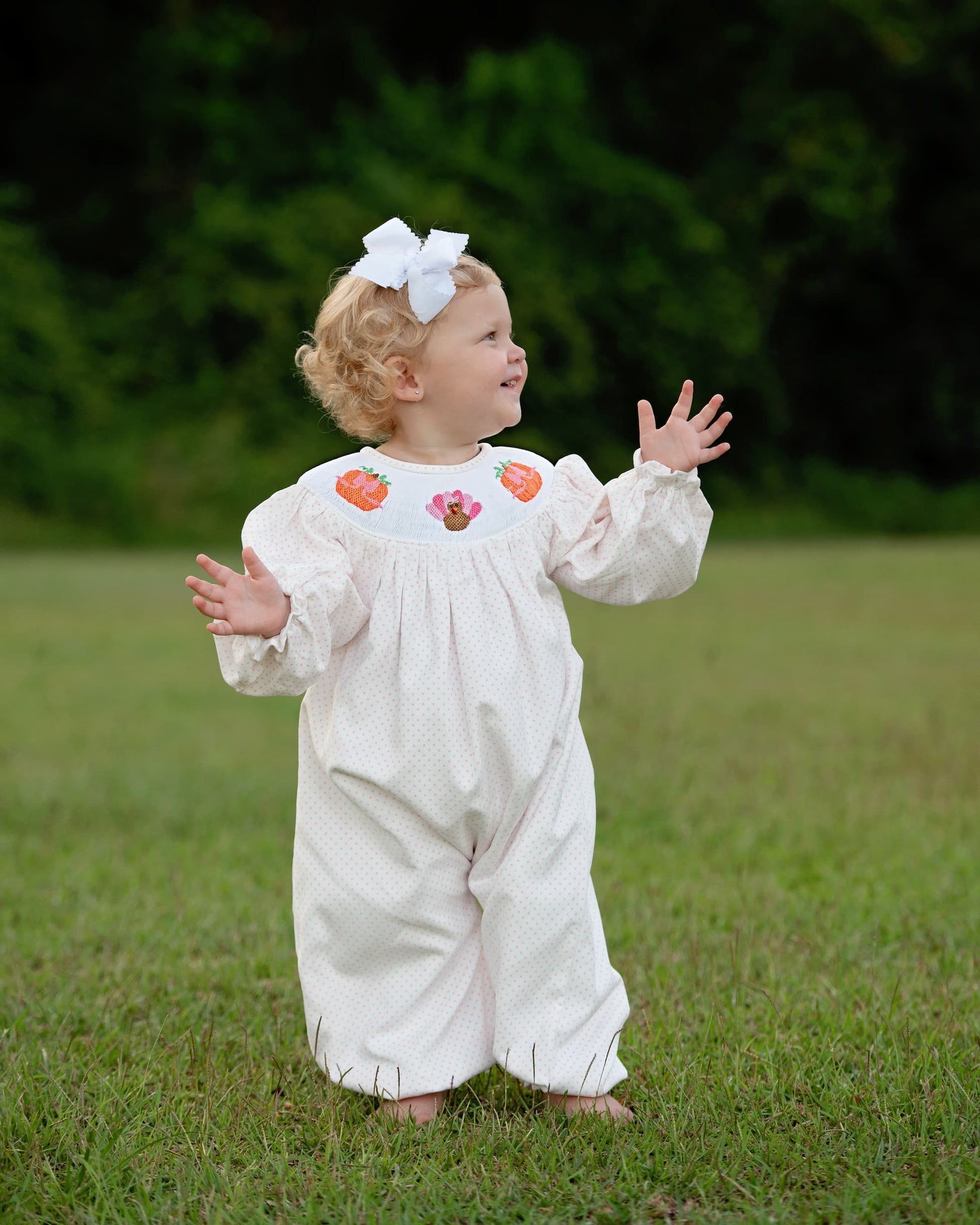 Young girl wearing pink dot turkey and pumpkin long bubble.