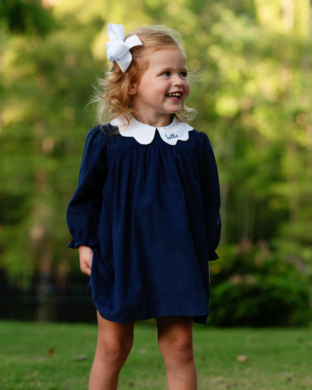 Girl wearing the Navy Corduroy Scalloped Collar Dress with name personalization
