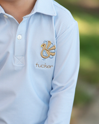 blue checkered shirt with a embroidered turkey and 'tucker' text on a blurred background