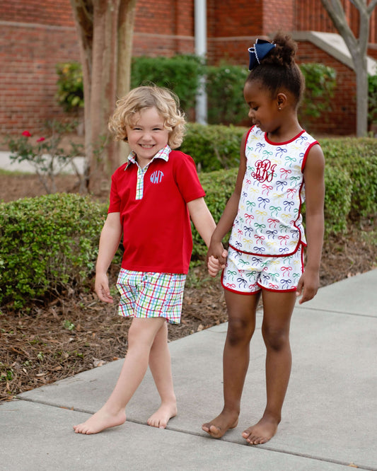 children standing on sidewalk holding hands wearing colorful outfits 
