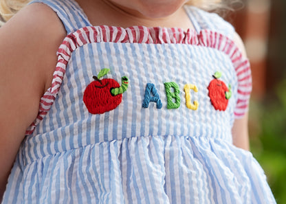 close up of a seersucker bubble with apples and "ABC" embroidered on the front