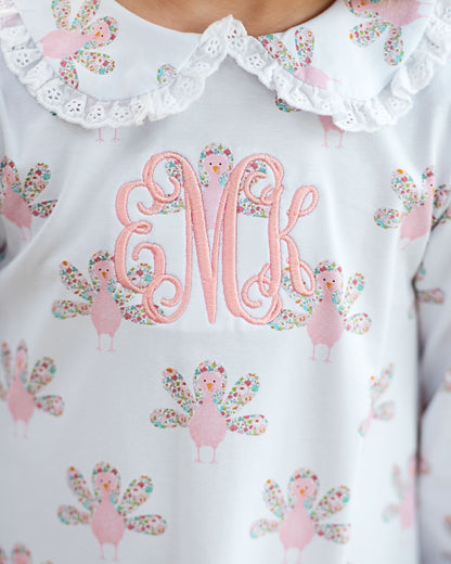 girl outfit with collar, monogrammed "eMk", and turkey pattern.