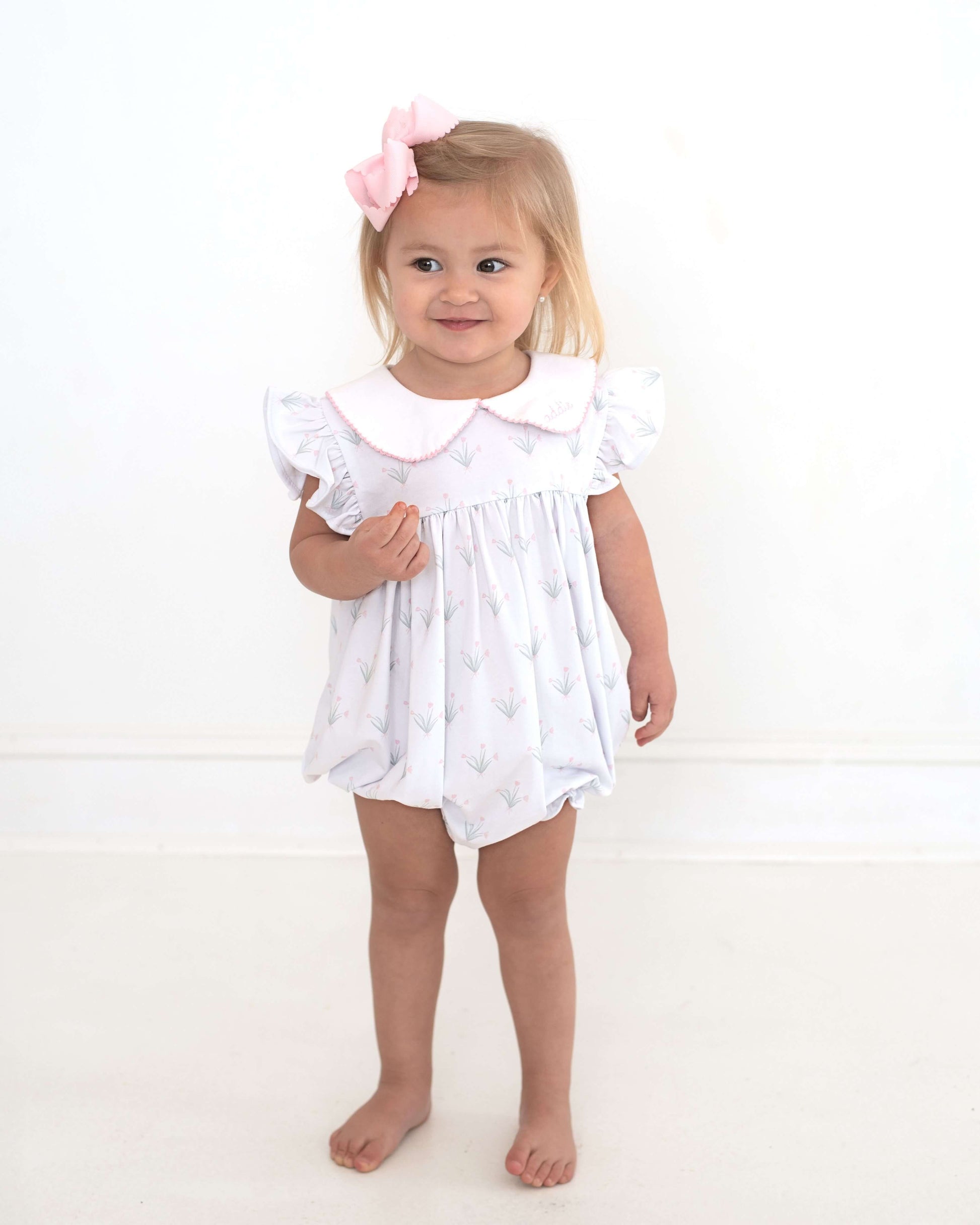 girl wearing a floral outfit and pink bow