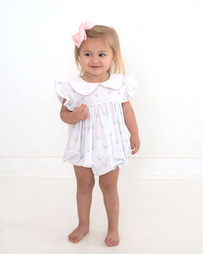 girl wearing a floral outfit and pink bow