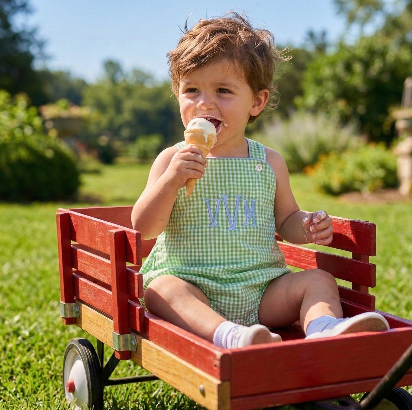 little boy sitting in a wagon eating ice cream