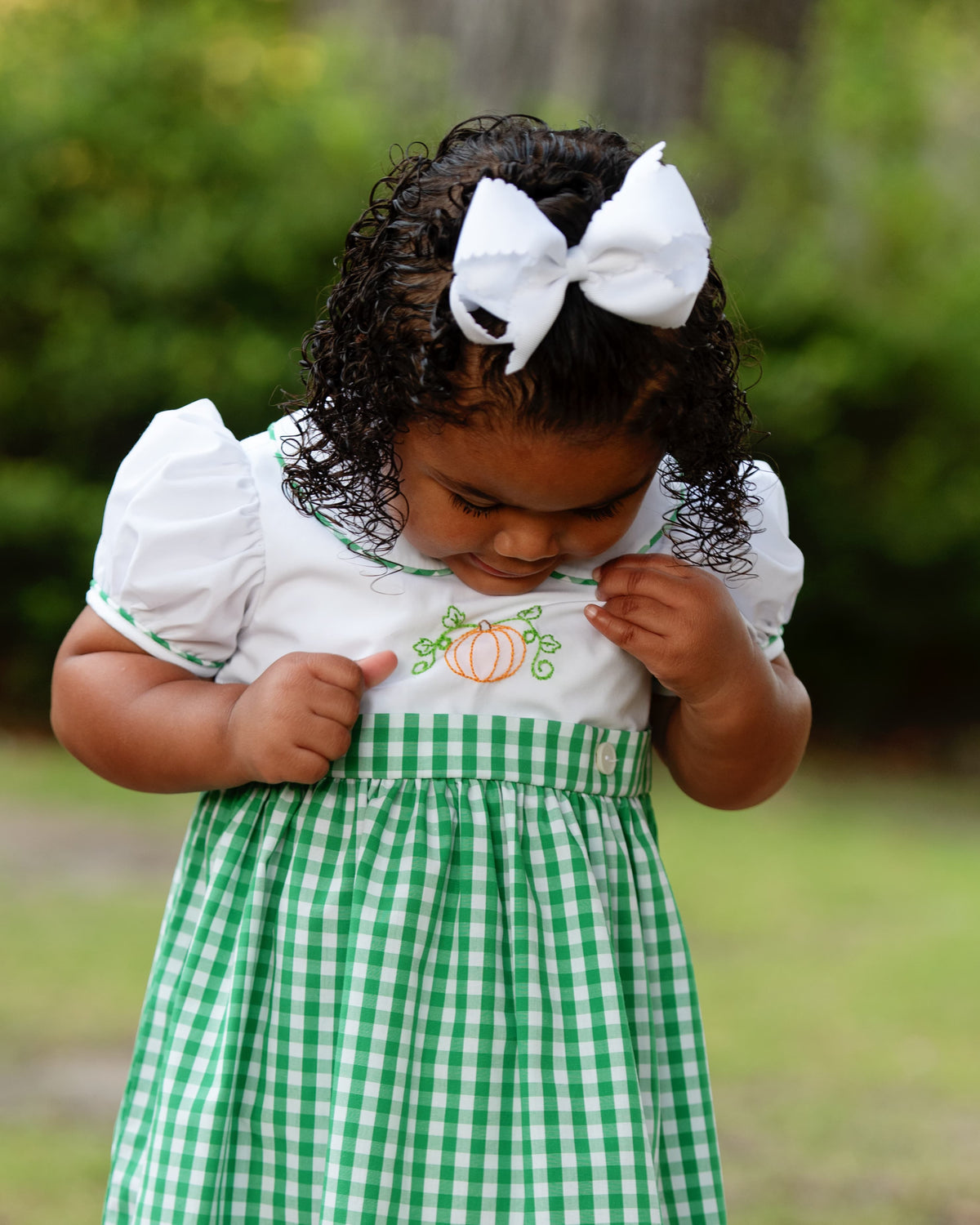 Girl wearing the Green Check Embroidered Pumpkin Dress outdoors
