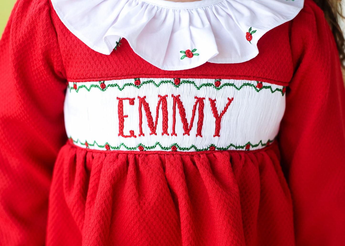 Red dress with white collar and embroidered name 'EMMY'