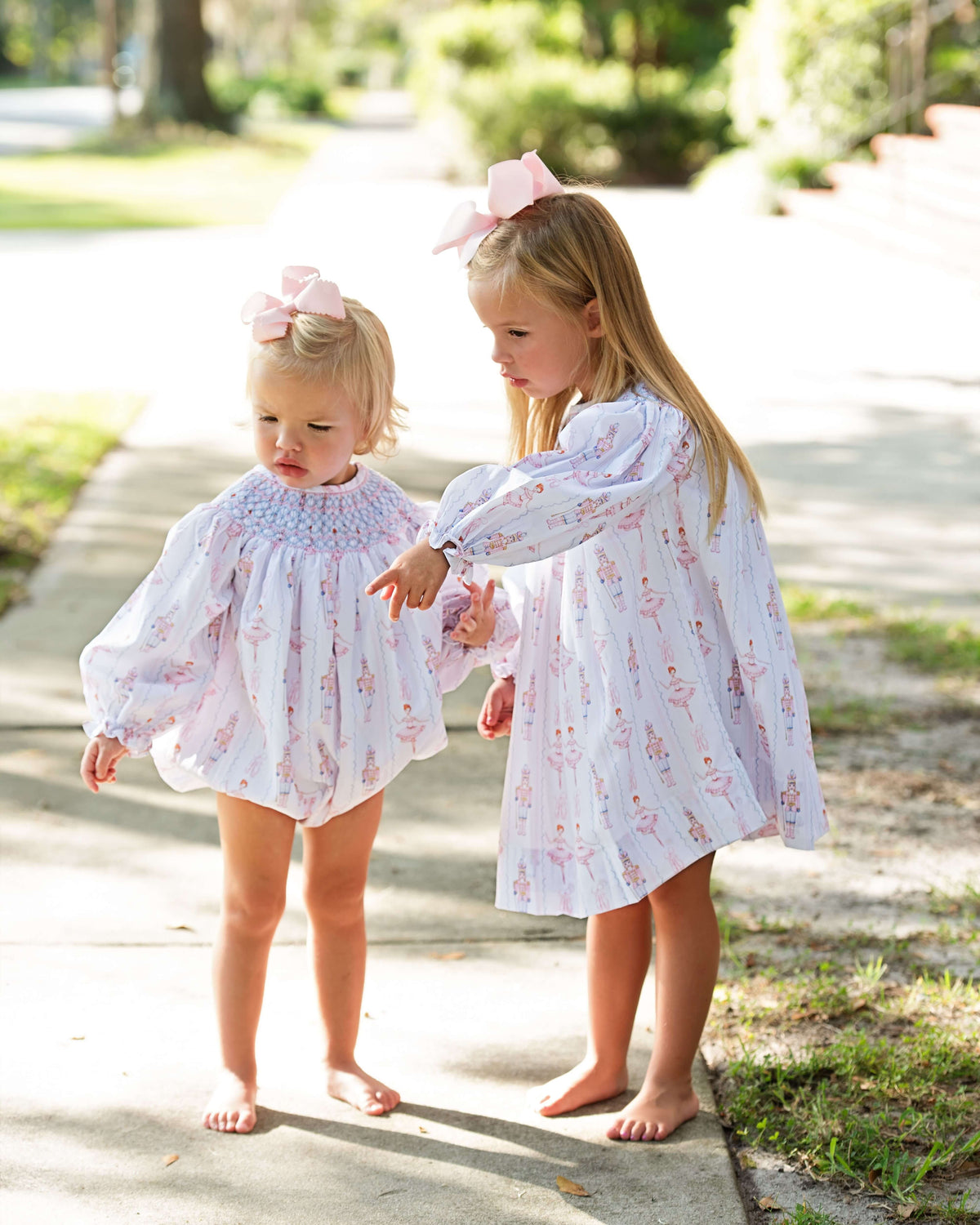 two young girls wearing matching smocked nutcracker bubble and dress