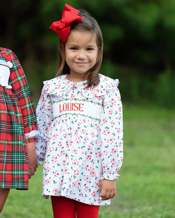 Young girl wearing a holiday floral custom smocked dress personalized with a name