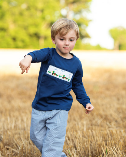 young boy playing outside in a field wearing a smocked mallard pant set