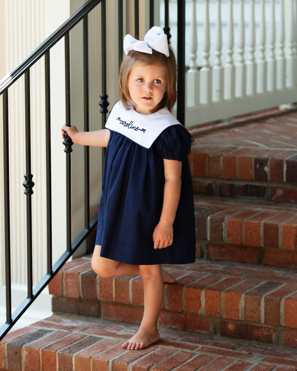 Girl wearing the Navy Corduroy Square Collar Dress with monogram