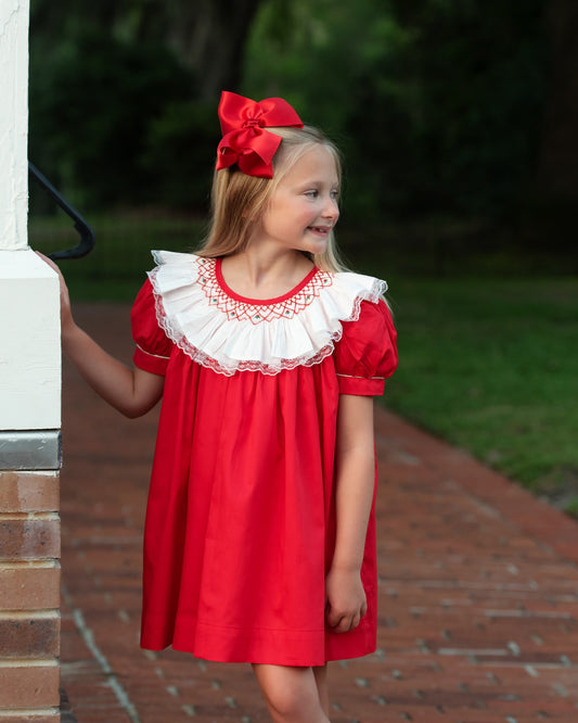 young girl wearing a red dress with an oversized lace collar with detailed smocking
